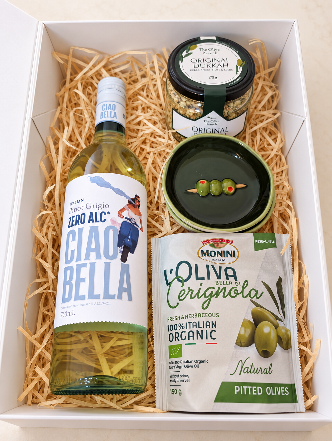 Olive & Aperitivo non-alcoholic gift box with Ciao Bella Zero Alc Pinot Grigio, Original Dukkah, green olives and a ceramic olive dish.
