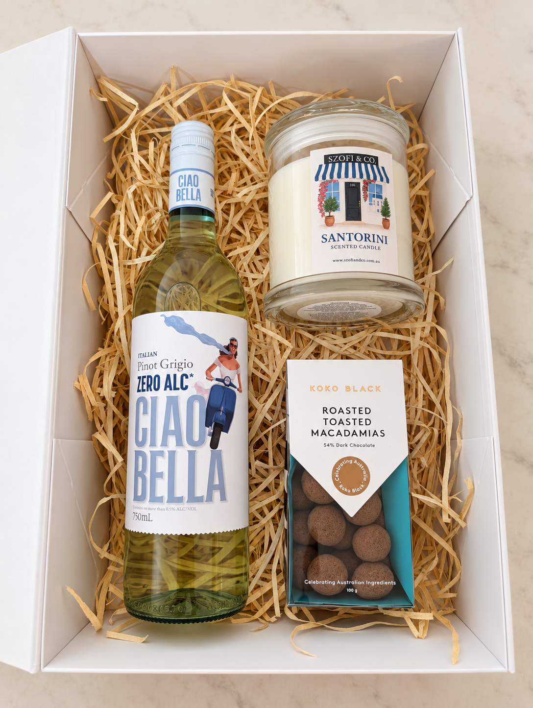 Ciao & Candlelight gift box with Ciao Bella Zero Alc Pinot Grigio, a large SZOFI & CO candle and Koko Black dark chocolate macadamias.