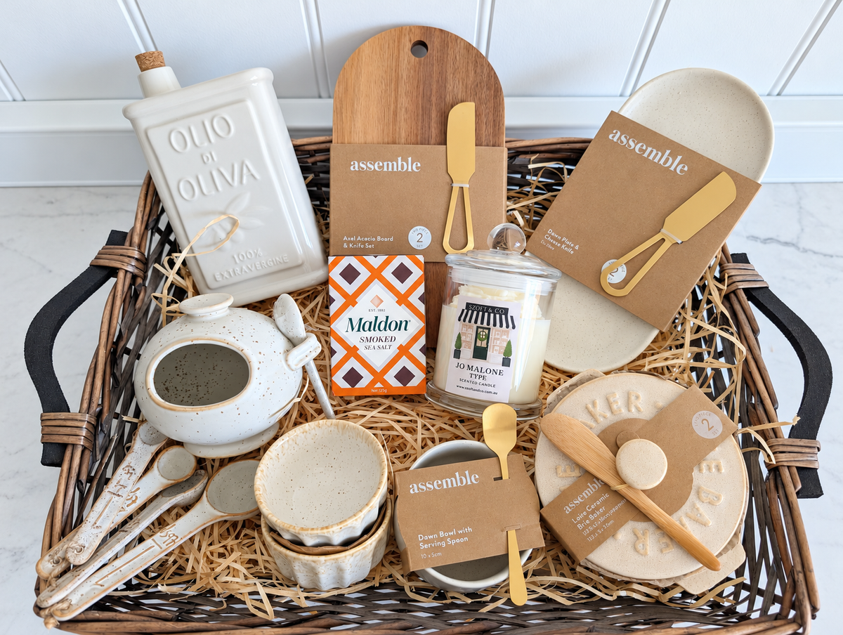 The Gather & Glow Hamper in a willow tray with ceramic kitchenware, acacia board, smoked sea salt and a Large SZOFI & CO candle