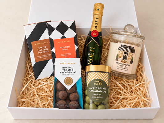 The Golden Indulgence Gift Box with Mini Moët Champagne, Koko Black chocolates and macadamias, and a large SZOFI & CO candle.