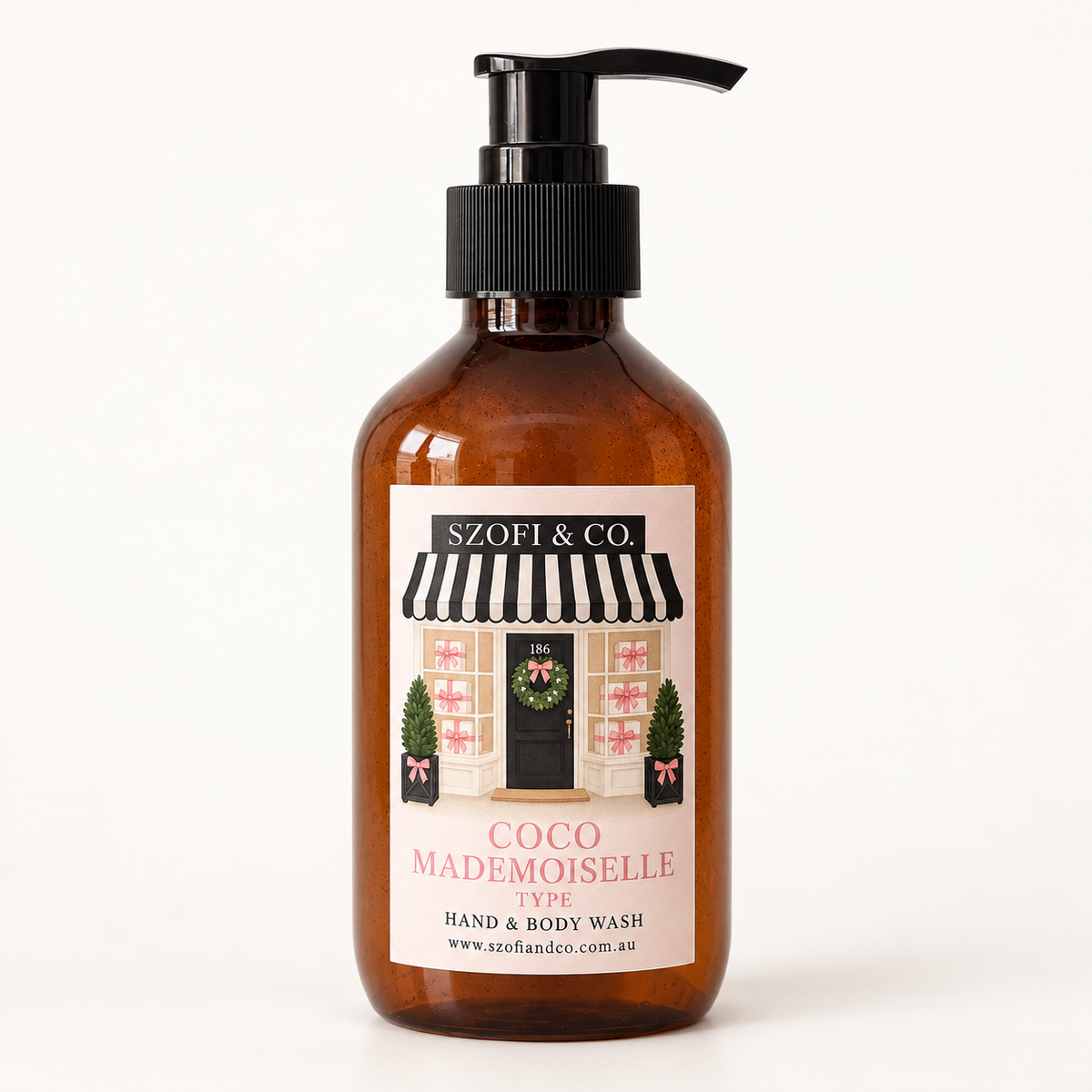 SZOFI & CO Coco Mademoiselle Type Hand & Body Wash in an amber pump bottle on a warm ivory background